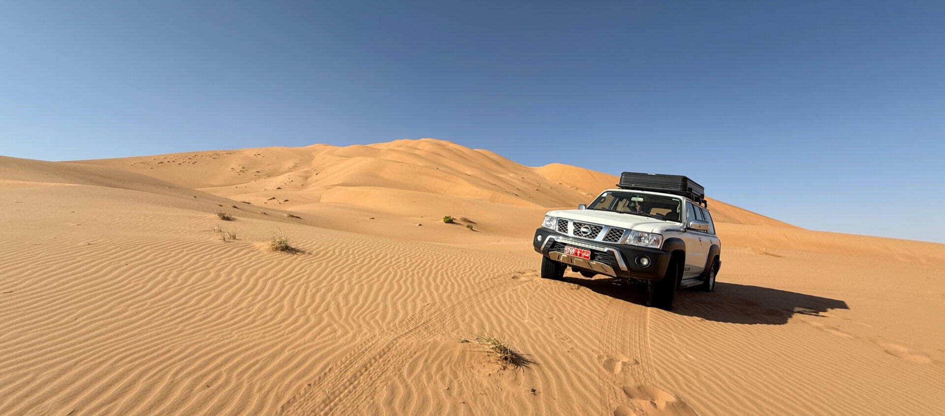 Nissan Patrol 4WD parked on sand dunes in the Omani desert | nomad