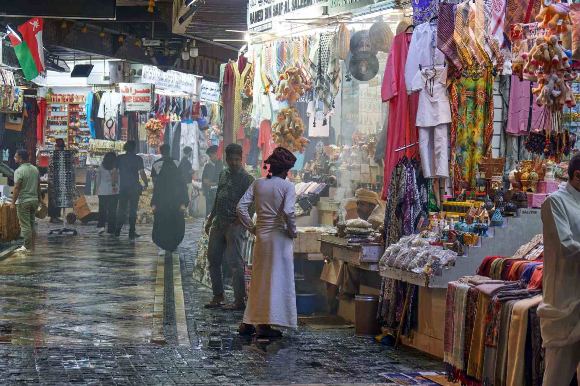 Traditional souq market street in Oman with local shops and textiles | nomad
