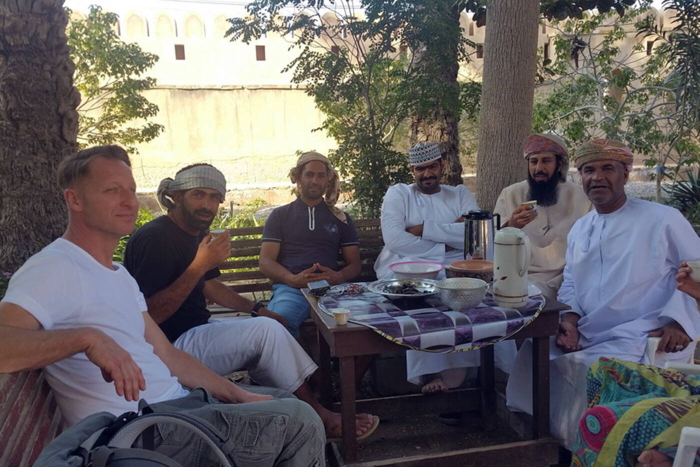 Sharing tea with local Omani hosts near a historic fort | nomad